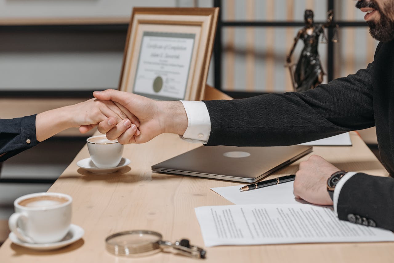 services-01 A formal handshake over a business contract in a corporate office setting.