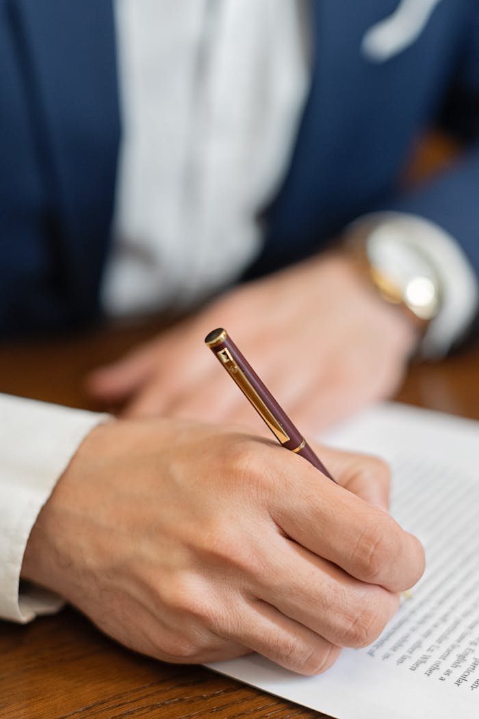 services-03 Close-up of a hand signing a business contract with a fountain pen.